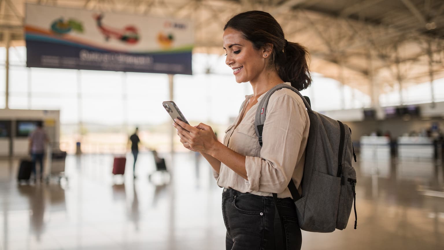 Una viajera activa revisando su teléfono en el área de llegadas del Aeropuerto Internacional Silvio Pettirossi de Asunción, Paraguay, con un letrero de 'Bienvenida' de fondo, simbolizando la facilidad de conexión al llegar.