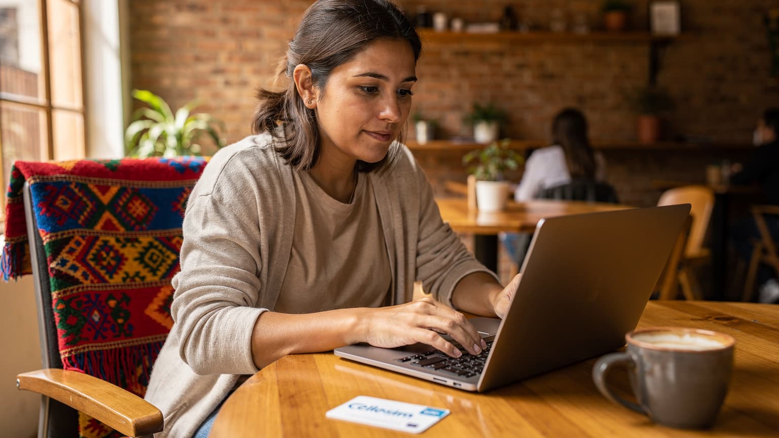 A digital nomad sits at a wooden table inside a cozy co-working space in La Paz, Bolivia, actively typing on a laptop with a Cellesim eSIM package visible on the table, a cup of coffee nearby, and traditional Bolivian textiles subtly decorating the background.