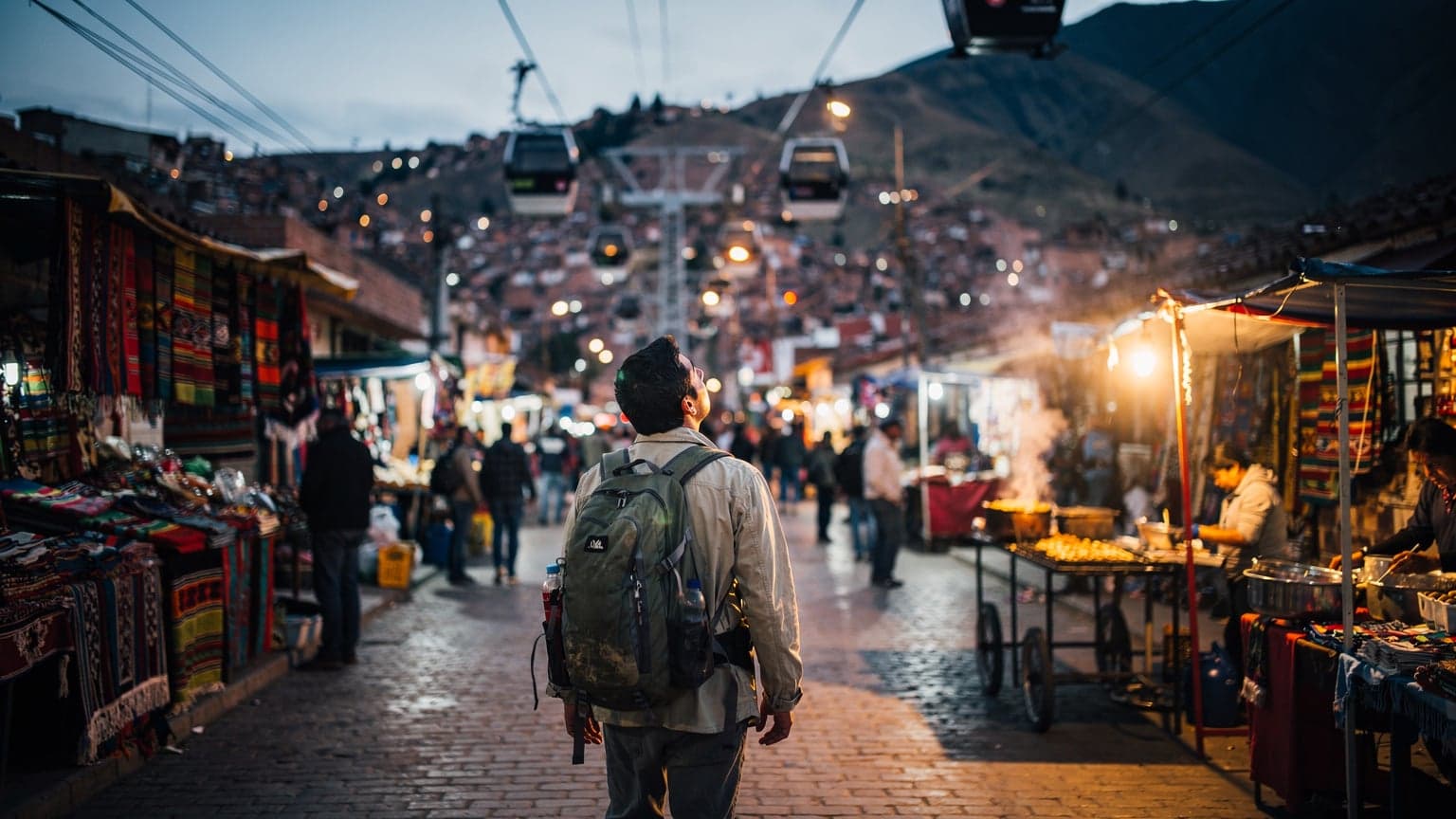 A bustling street scene in La Paz, Bolivia, at dusk, with street vendors and people moving through the glowing market stalls, the iconic cable car lines visible against the darkening sky.