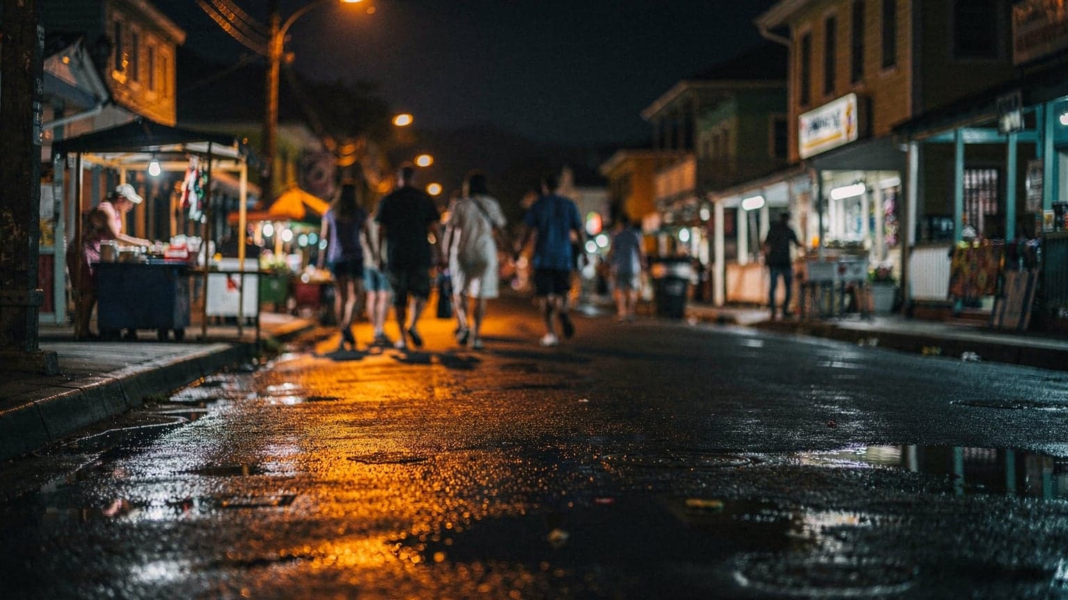 Noční ulice v Castries na Svaté Lucii, lidé se pohybují kolem rozsvícených stánků, dokumentární snímek s pohybovou neostrostí