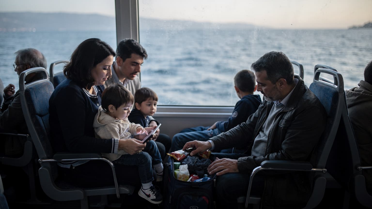 Marmara Denizi'nde bir vapurda, sabahın erken saatlerinde, iki çocuklu bir ailenin eşyalarını düzenlerken çekilmiş doğal bir fotoğraf. Baba çantaları kontrol ederken anne çocukların tabletlerine bakıyor.