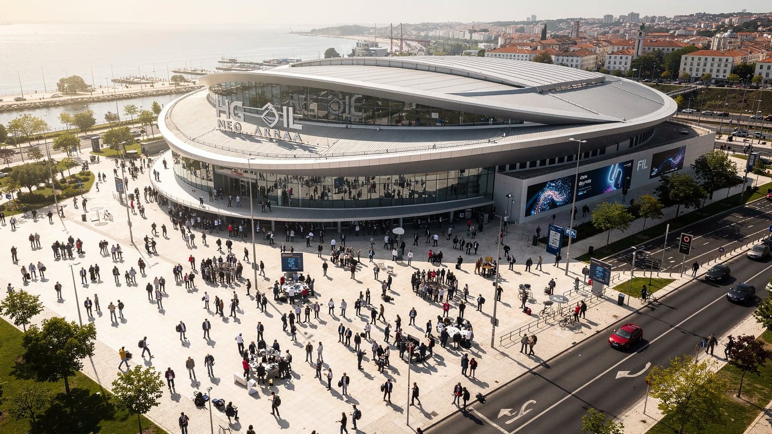 Vue aérienne du centre de conférence MEO Arena et FIL à Lisbonne, avec des participants se dirigeant vers l'événement, symbolisant la connectivité mondiale.