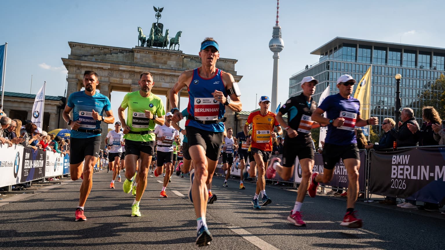 Corredores participando da Maratona de Berlim, com a cidade ao fundo, simbolizando conectividade durante o evento.