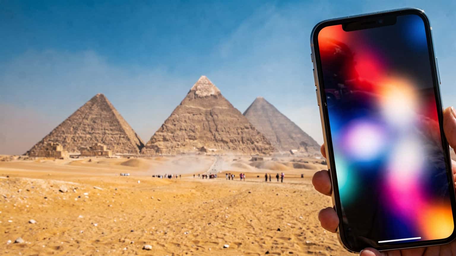 Une vue panoramique des pyramides de Gizeh au lever du soleil, avec un smartphone en premier plan affichant un signal réseau.