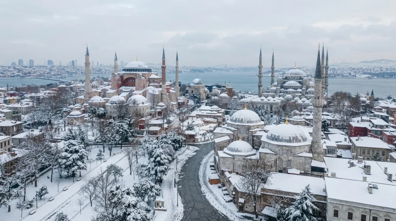 Pemandangan kota Istanbul yang tertutup salju di musim dingin, dengan menara masjid dan bangunan bersejarah terlihat di kejauhan, mencerminkan suasana liburan musim dingin di Turki.
