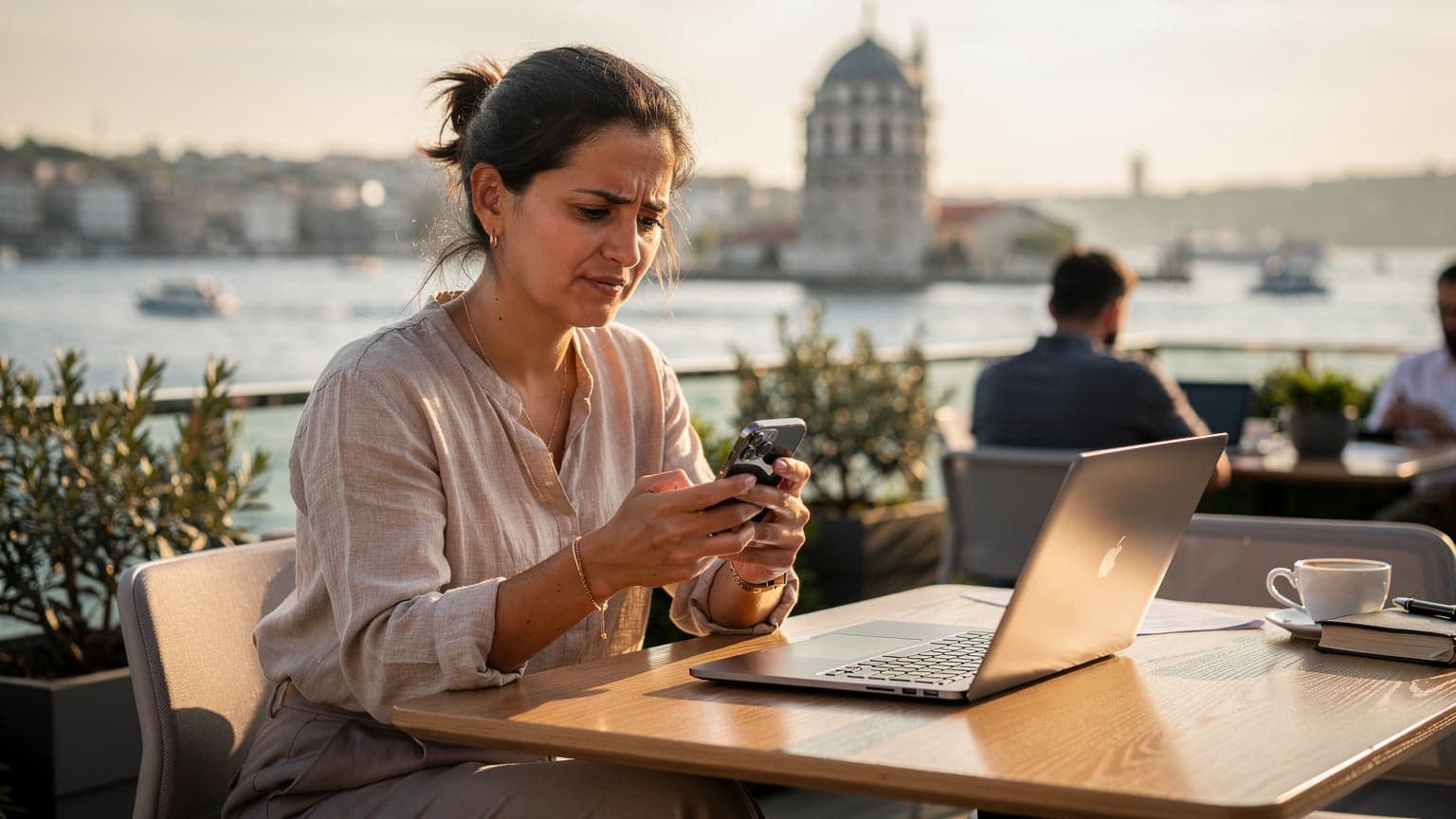 İstanbul'da bir kafe terasında, elinde akıllı telefonla bağlantı sorununu çözmeye çalışan bir dijital göçebe.