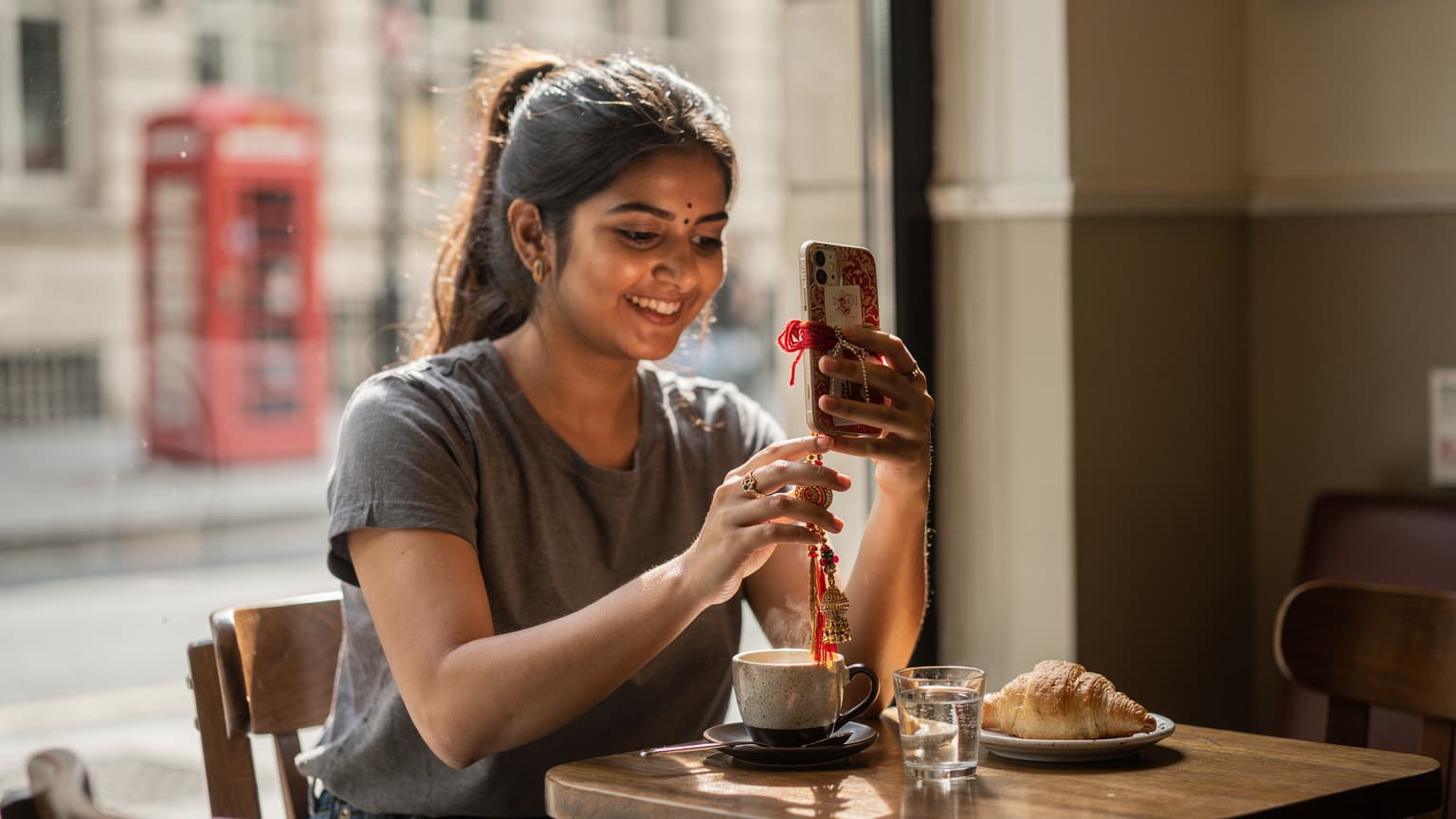 एक भारतीय परिवार वीडियो कॉल पर रक्षाबंधन का त्योहार मना रहा है, जिसमें एक बेटी अपने भाई को विदेश से राखी भेज रही है।