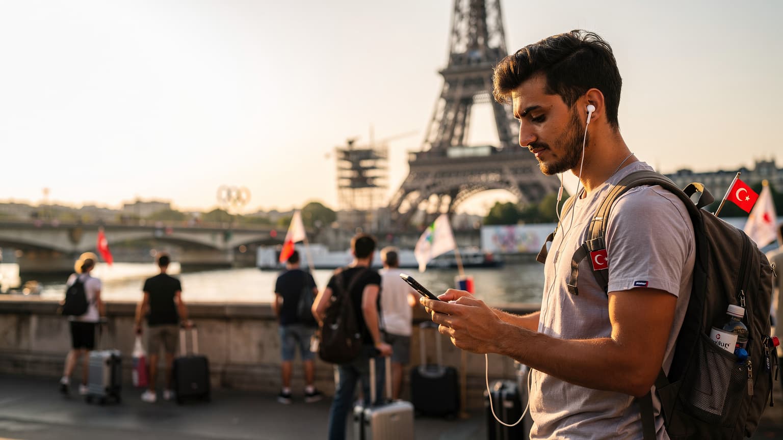 Paris'in Eyfel Kulesi yakınlarında, bir Türk seyahatseverin telefonunda haritalara bakarken gülümsediği bir an.