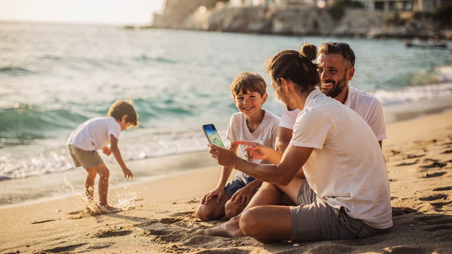 A family on a sunny beach in Bulgaria or Greece, with a parent subtly using a smartphone, symbolizing easy travel connectivity.