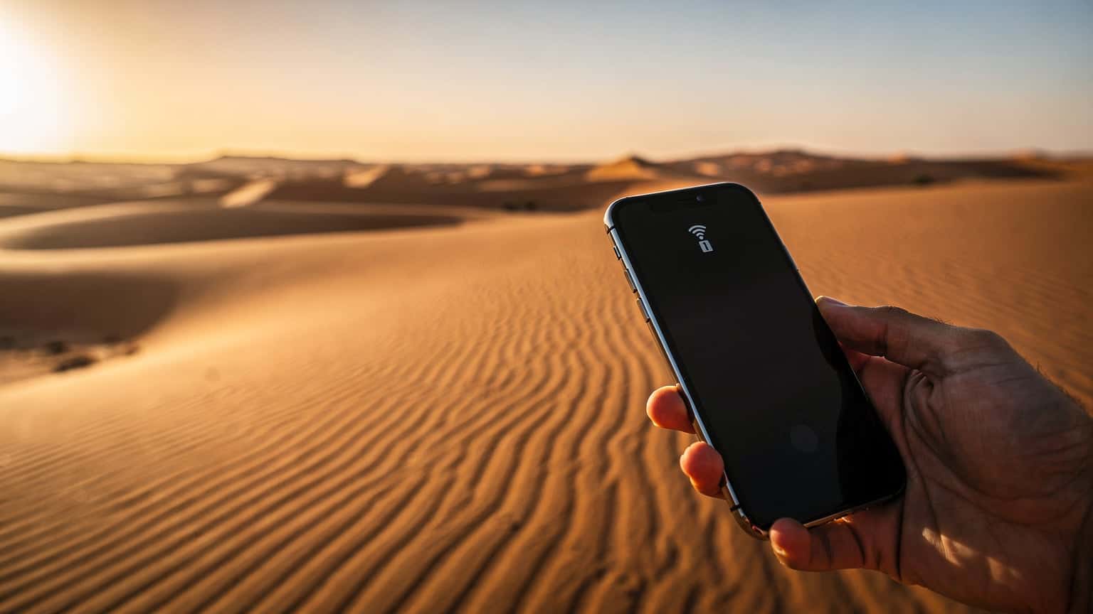 A photorealistic hero image depicting a hand holding a modern smartphone against a backdrop of vast, sunlit golden sand dunes in the Moroccan desert during golden hour, symbolizing fast and convenient internet connectivity for exploring remote areas.