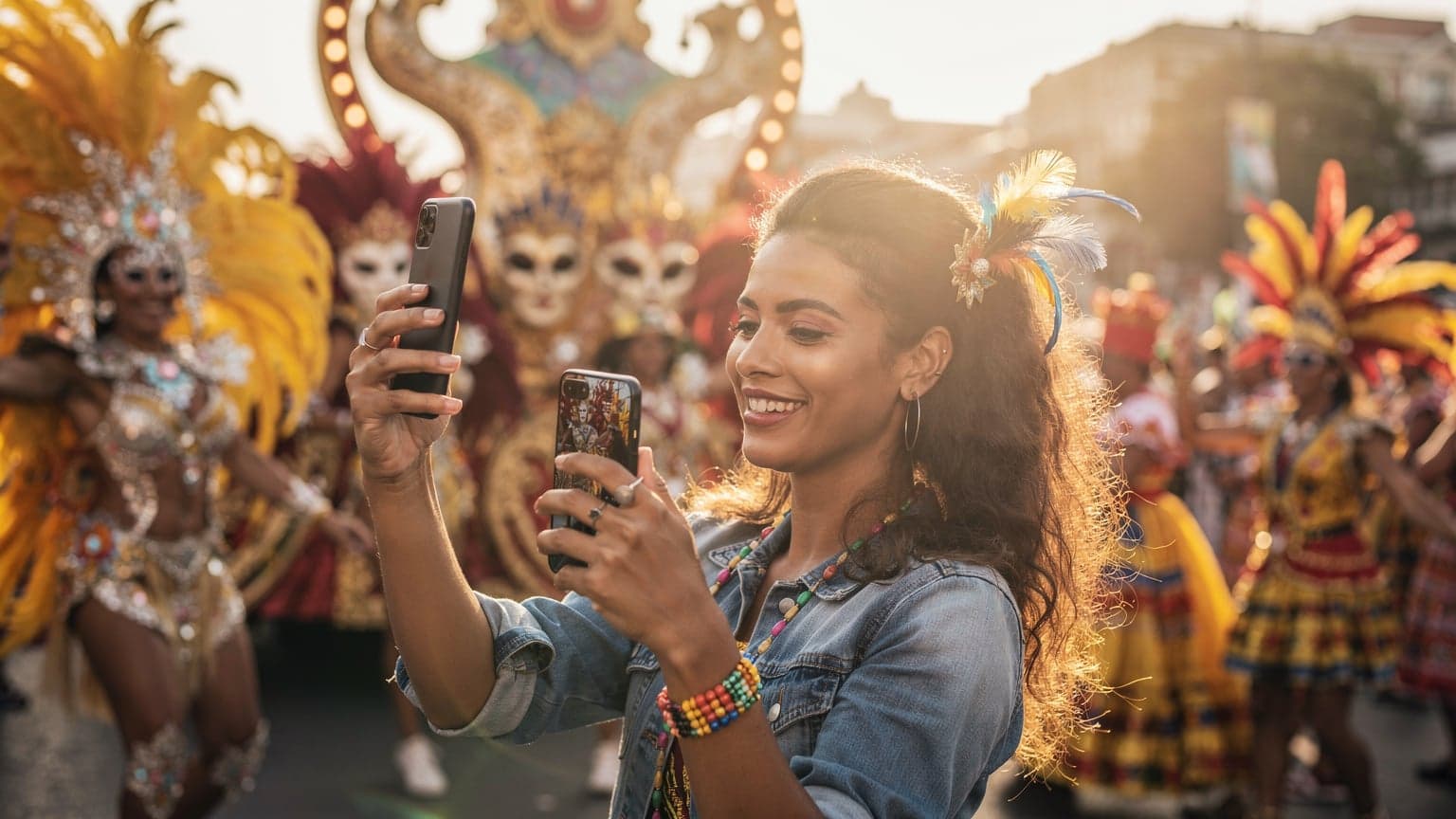 A person using a smartphone to capture a vibrant, colorful carnival parade with elaborate costumes and dancing crowds, symbolizing global connectivity during festivities.