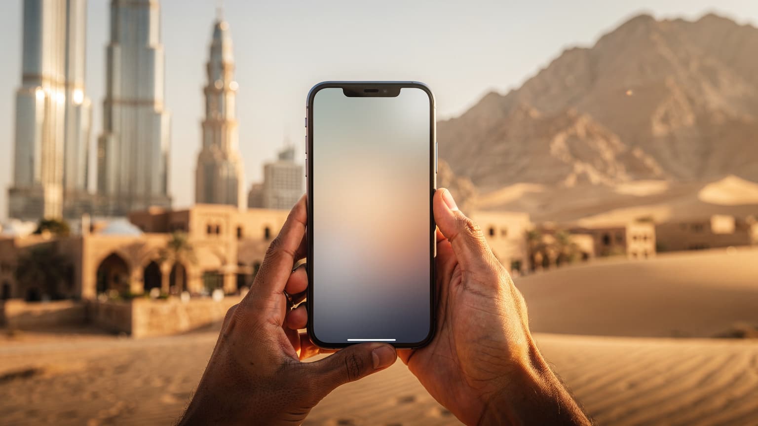 A close-up, editorial photograph of a modern smartphone held in hands, with a beautifully blurred, sun-drenched Middle Eastern landscape (combining modern cityscapes and traditional desert elements) in the background. The image evokes seamless travel and digital connectivity in the region.